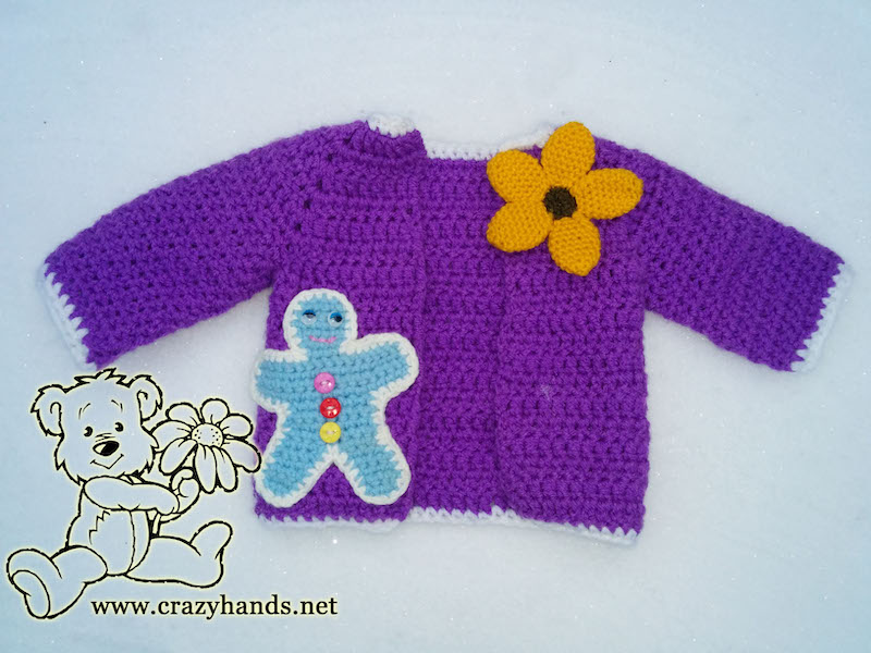 crochet gingerbread man used as a decor element on the crochet baby cardigan