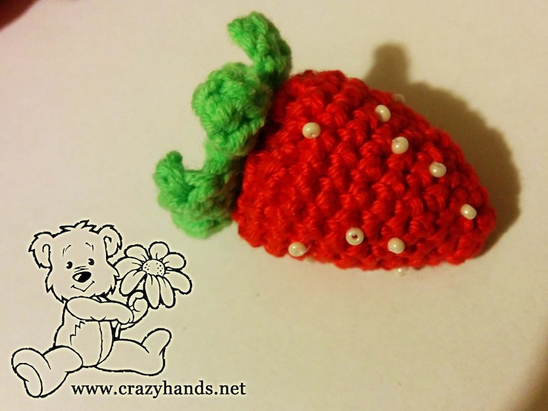 crochet red strawberry with green leaves