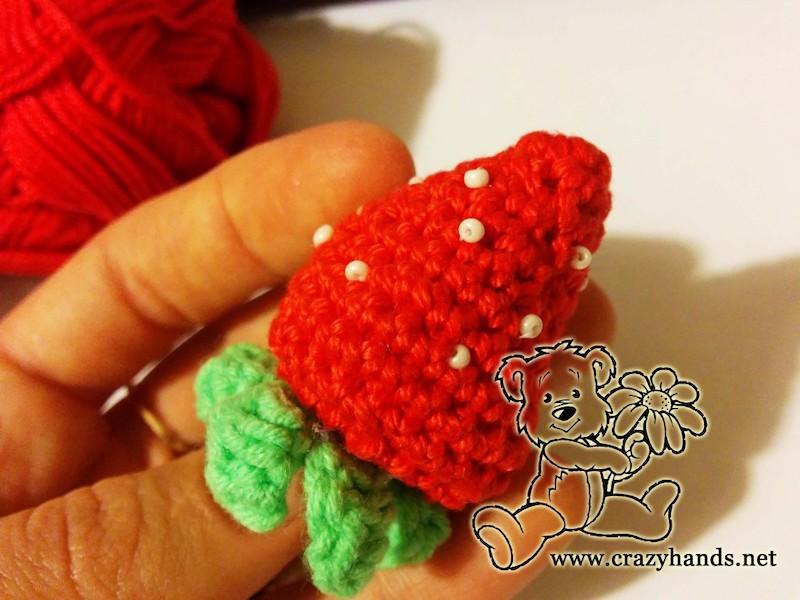 crochet red strawberry with white dots and green leaves