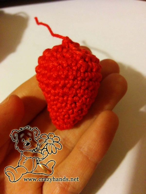 closing the top of the filled crochet strawberry
