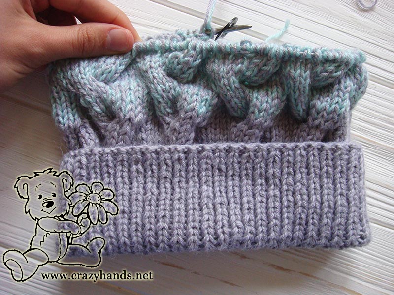 half-knitted baby hat with ear flaps