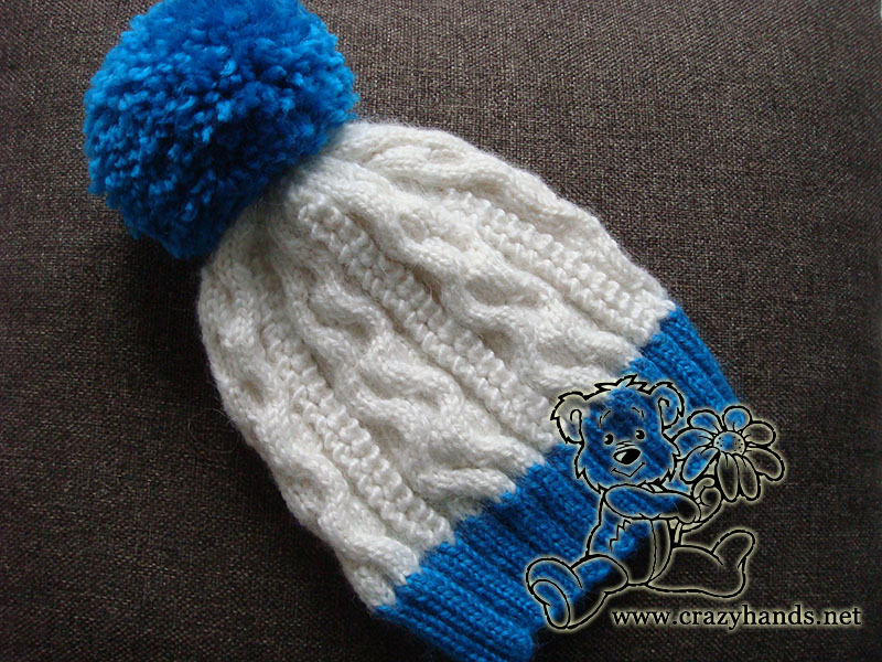 two color cable knit hat with yarn pom pom