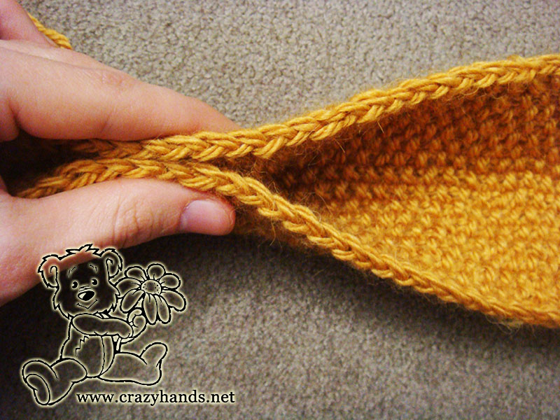 folding seed stitch headband in the middle to attach a bow knot