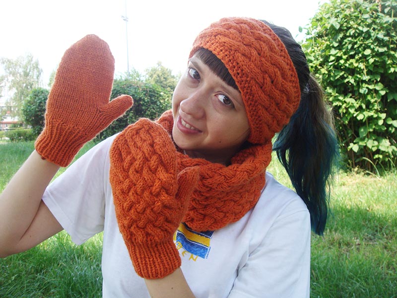 model woman wears a chunky knit cable set: mittens, cowl, and headband