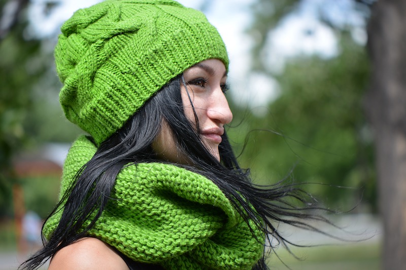 women wears shamrock green cable knit beanie and infinity scarf