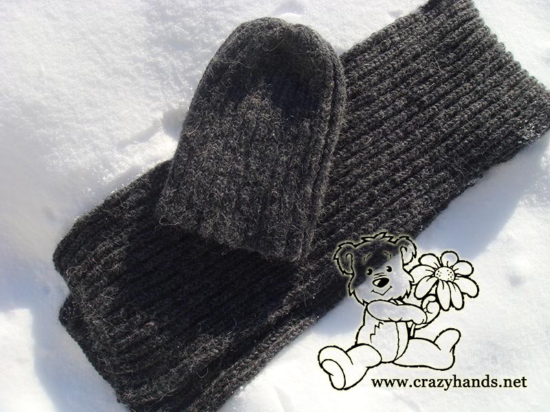 fisherman's rib men's knit scarf and men's slouchy knit hat arranged on the snow