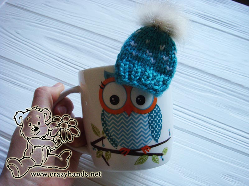 cup decorated with knit mini hat