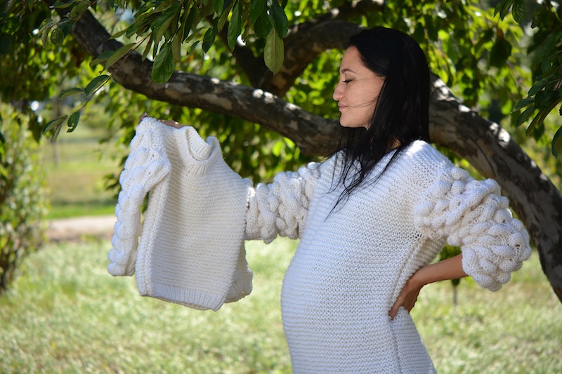 oversize knit sweater with bobbles on a woman model holding matching baby size sweater