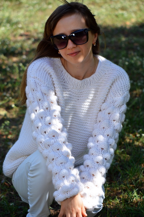 woman model wears oversized knit sweater with bobbles made with white yarn