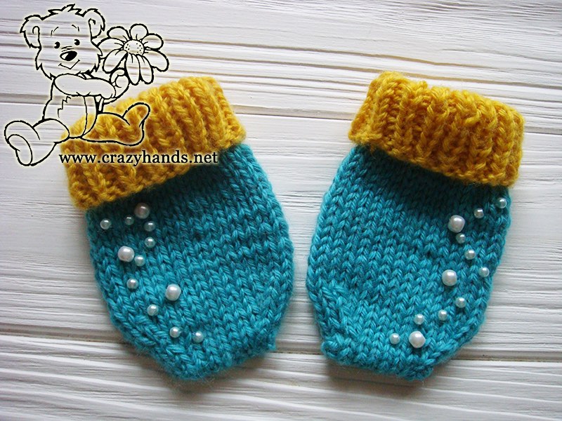 A pair of blue primrose knit mittens with pearls embroidery