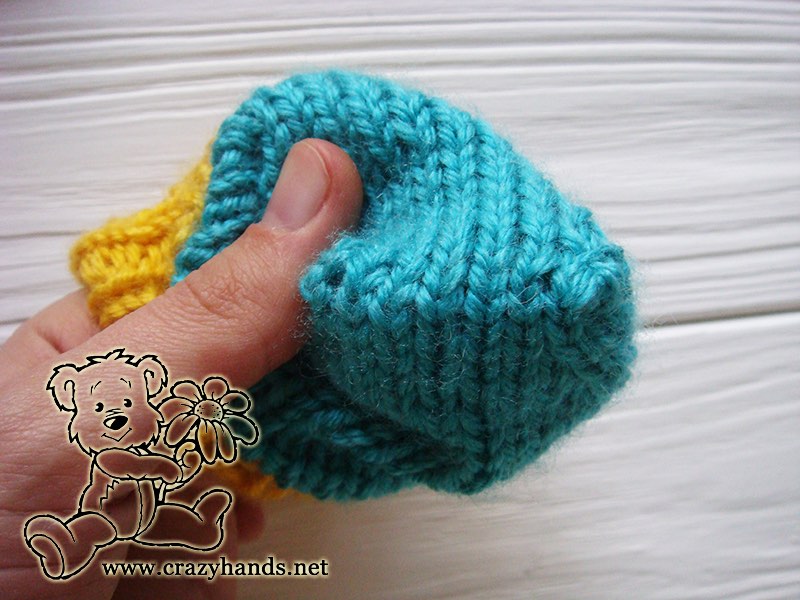 shaping the top of a newborn baby thumbless knit mitten