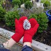 Christmas-style garter stitch knit mittens and white pinecone