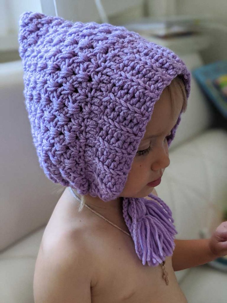 baby girl wears a crochet pixie hat of violet color