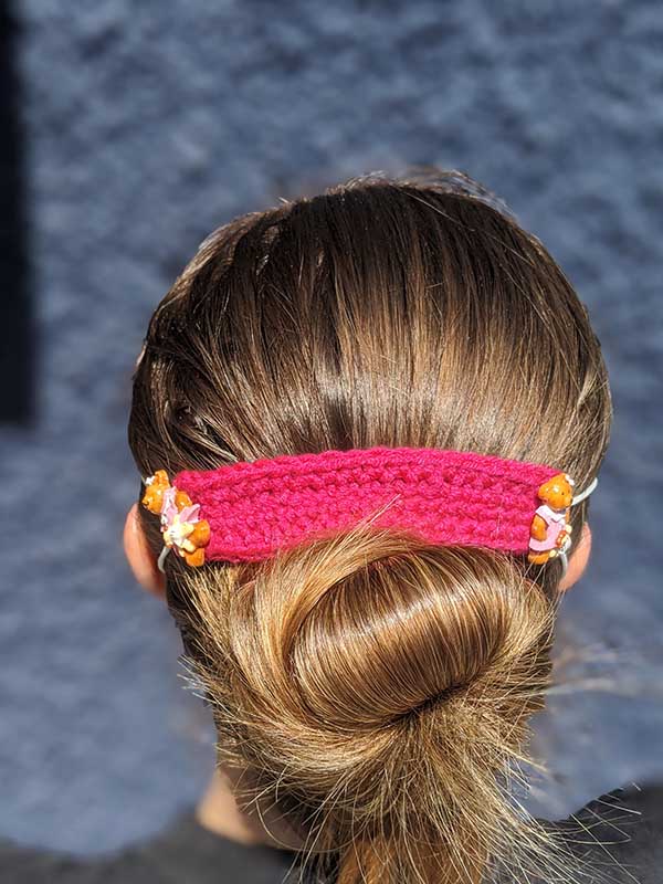 backside view of the crochet ear protector on a female model