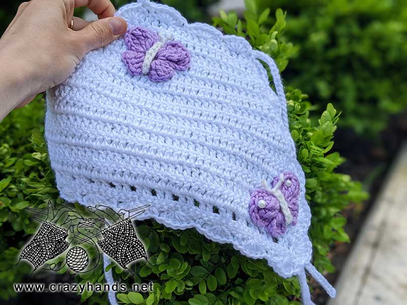 handmade white baby top decorated with two crochet butterflies made with violet yarn