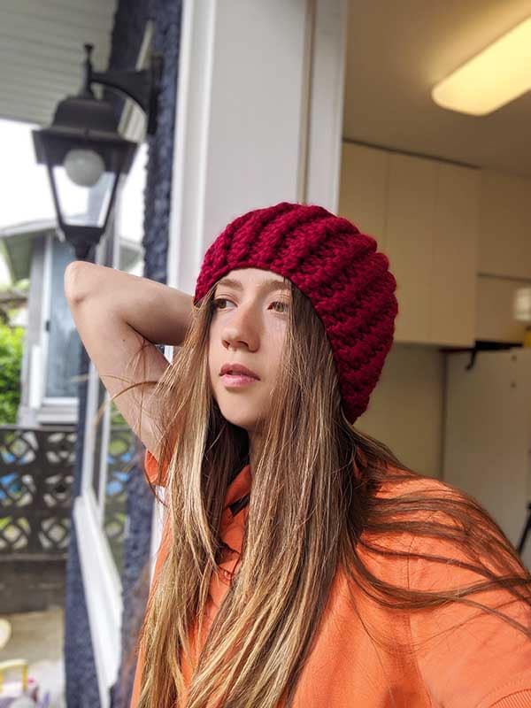 front shot of the female model wearing dark red ribbed knit hat