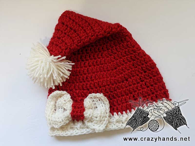 big crochet bow decorates crochet santa hat