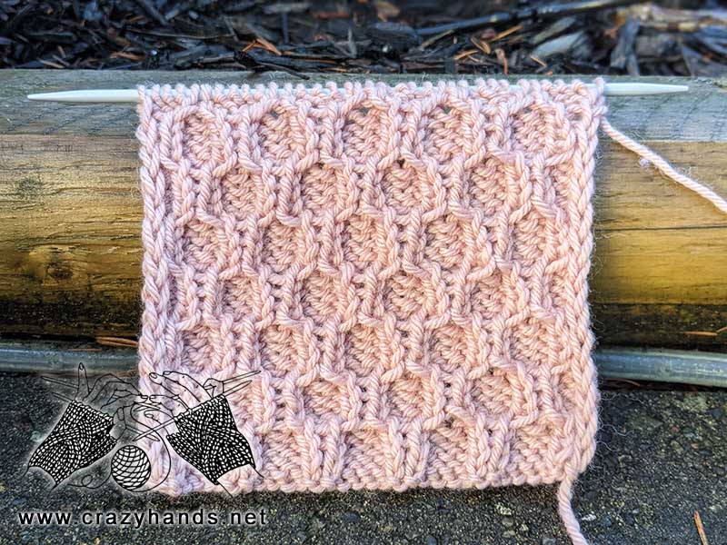 knit honeycomb stitch pattern made with pink yarn. sample size - 10 cm by 10 cm