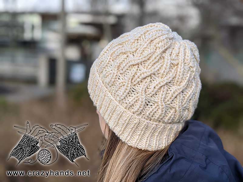 female model wears bulky knit liana cable hat - backside view