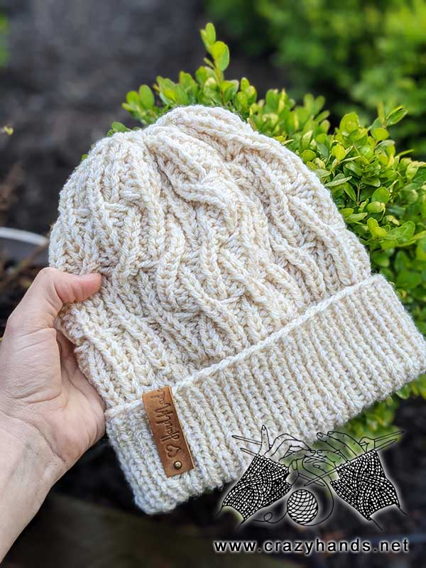 liana bulky knit cable hat with greenery on the background