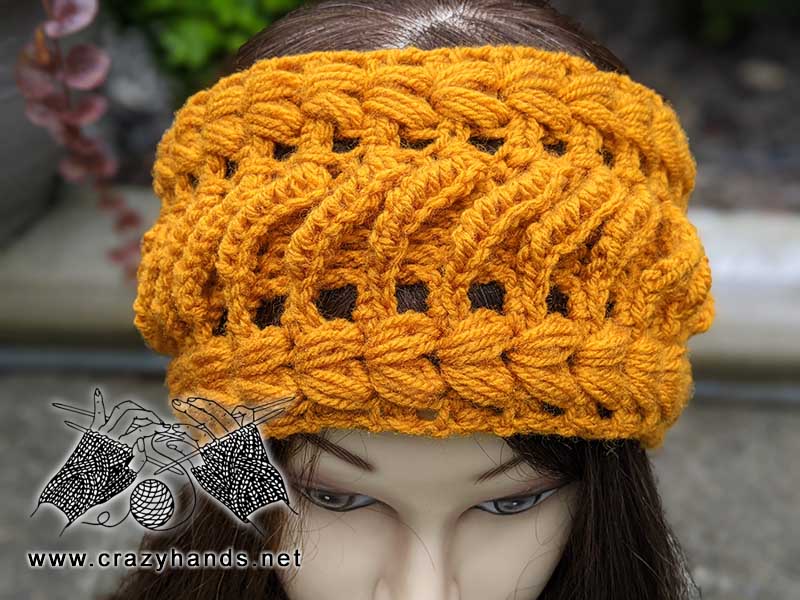 goldenberry crochet lace ear warmer on the mannequin's head - front view
