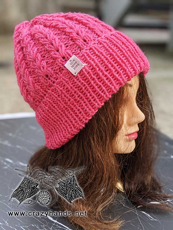 Ribbed hat knitted with fishtail stitch shown on the mannequin's head - front view