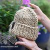 super bulky knit hat is held in hands with nature in the background