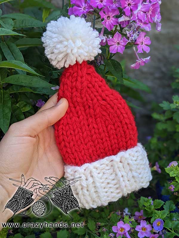 knit mini santa hat or christmas tree topper - shot on the greenery background