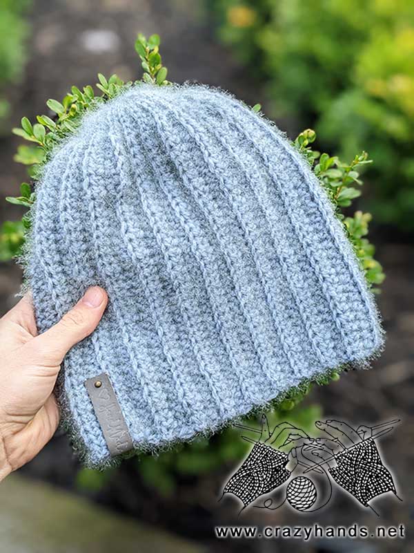 beginner-level classic crochet beanie on the green background