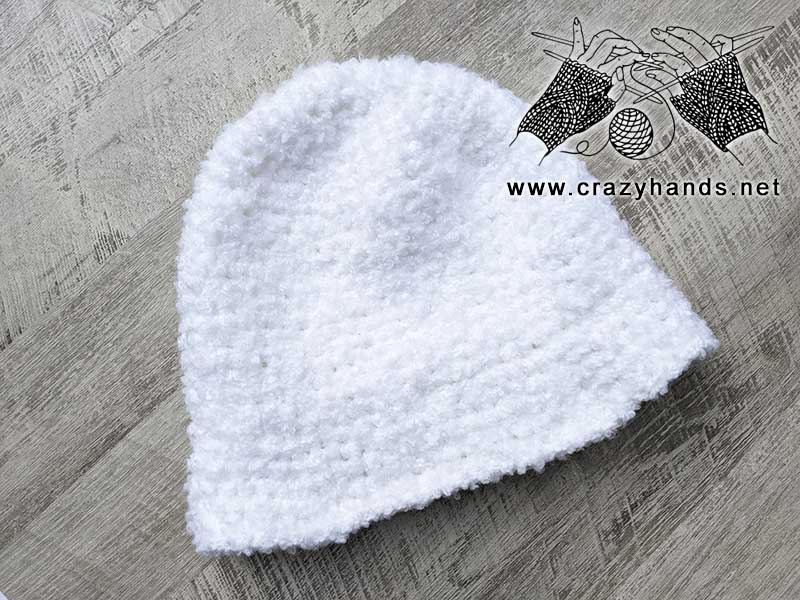 white crochet bucket beanie with poles on the wooden background