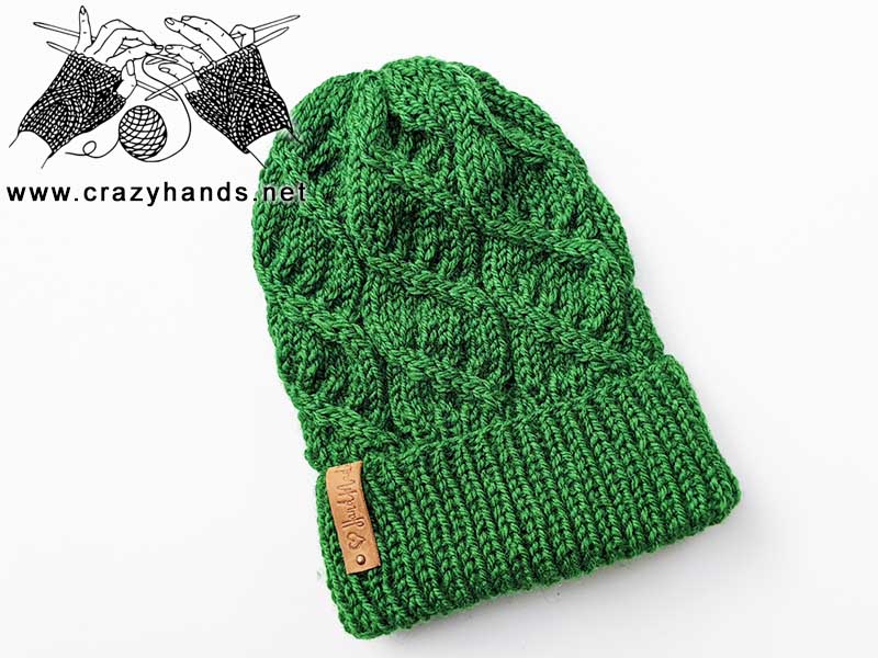 helix cable knit hat made with green yarn on white background