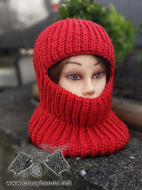 knit balaclava on the mannequin head made with red yarn