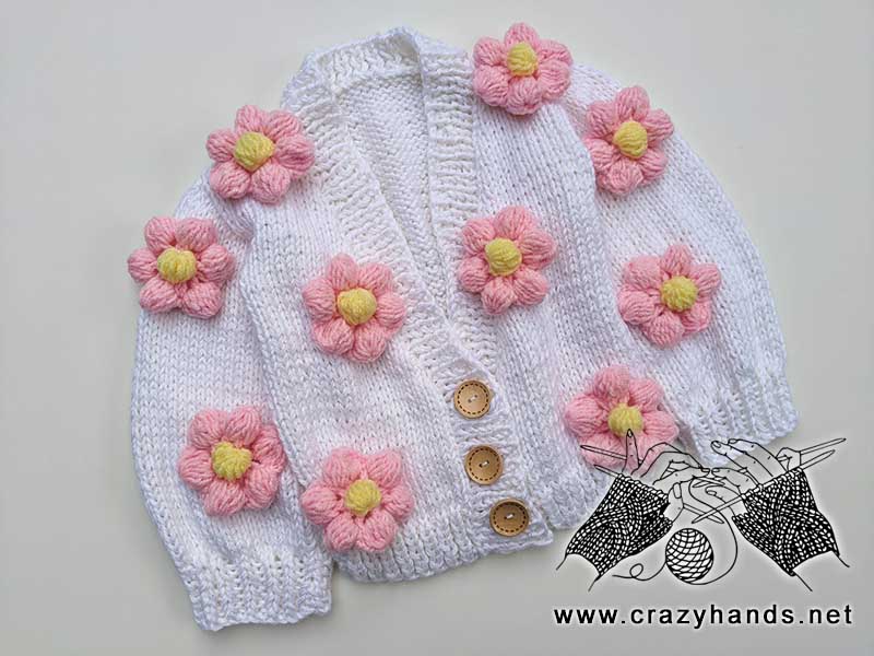 knit white cardigan for a child with pink and yellow flowers