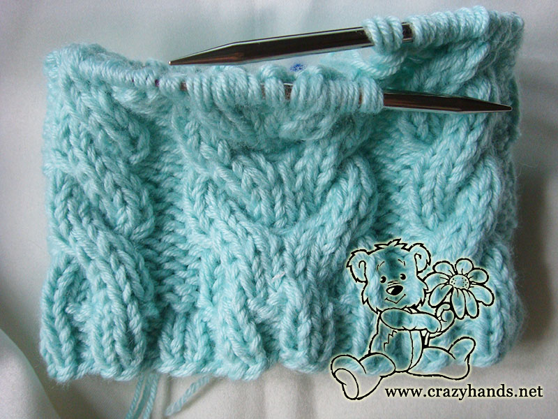 body of cable knit baby hat with ear flaps