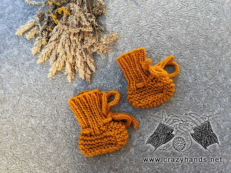knit newborn baby booties made with orange yarn