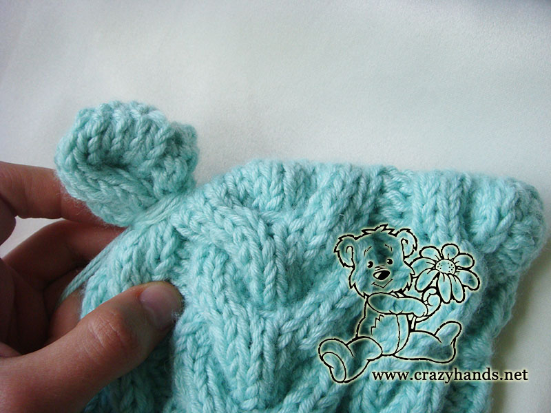 knitting ear of baby cable hat with ear flaps