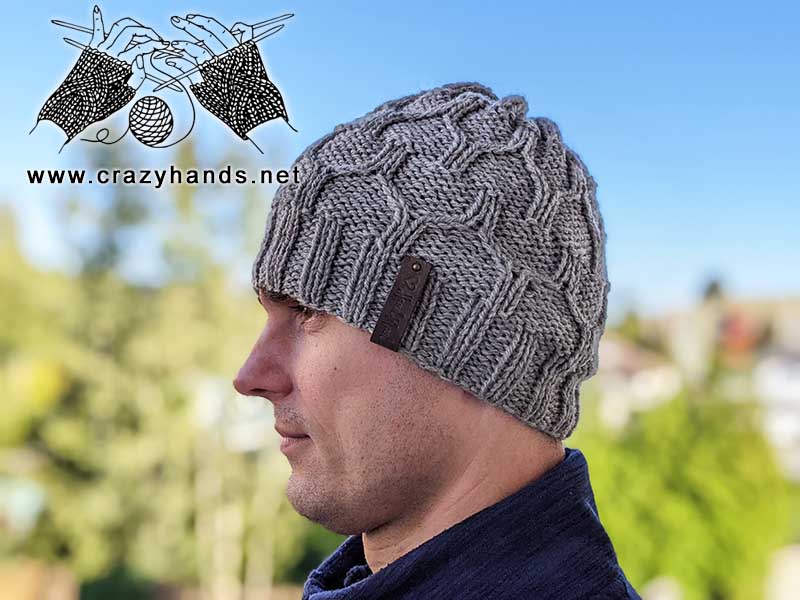 male model wears a cable knit hat made with bulky yarn