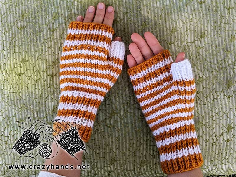 two needles flat knit hand warmers on female hands - top and bottom view of the hand warmers
