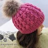puff stitch knit hat with fur pom pom on the mannequin's head