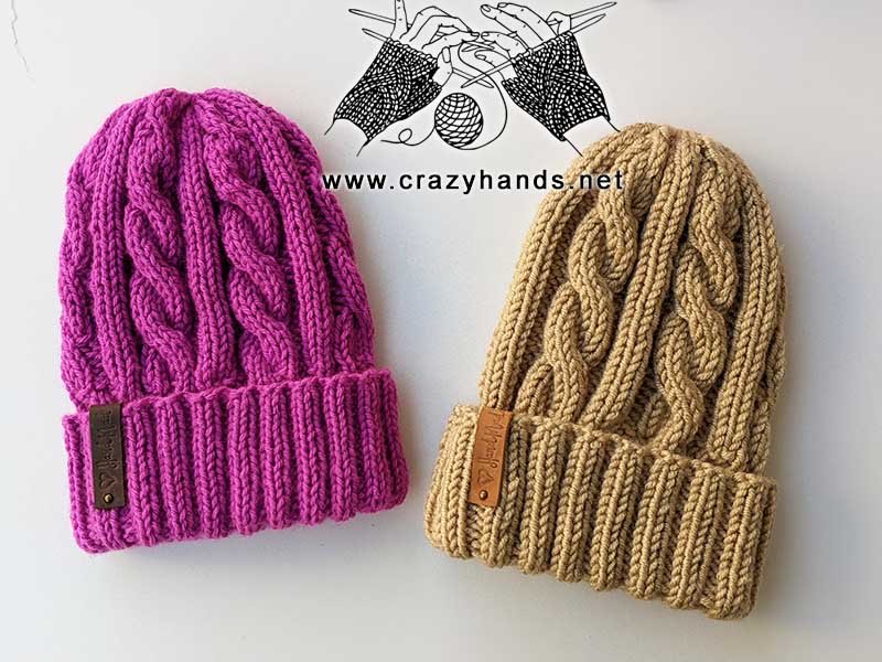 two medium-weight yarn cable knit hats - one hat made with brown yarn and another one with purple yarn