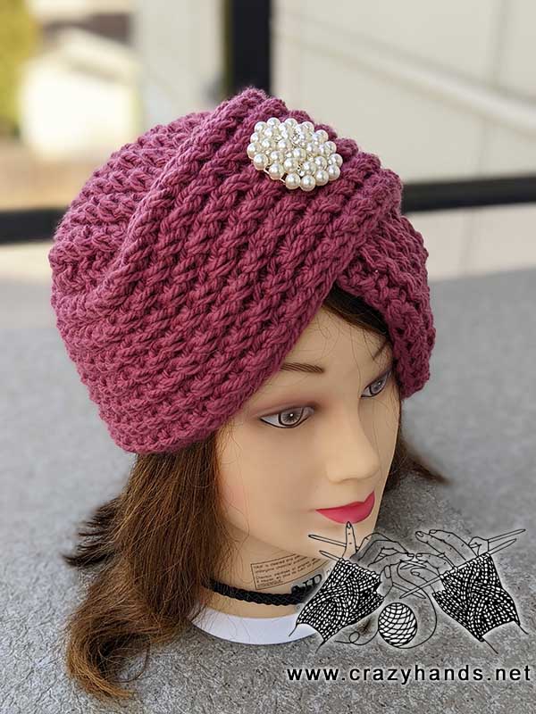 knit turban hat with brooch on the mannequin's head - left side view