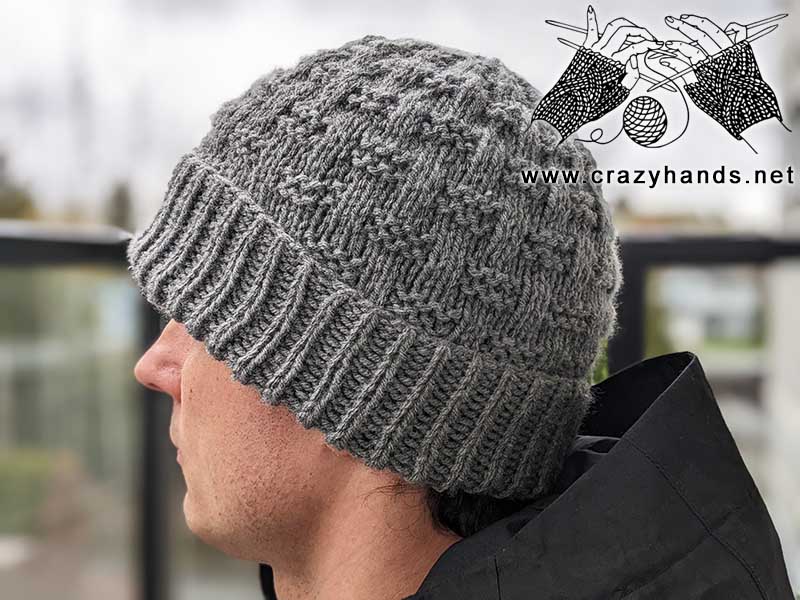 easy knit hat pattern for men. The hat has a folder brim and a stylish design. Photo made from the left side on a male model.