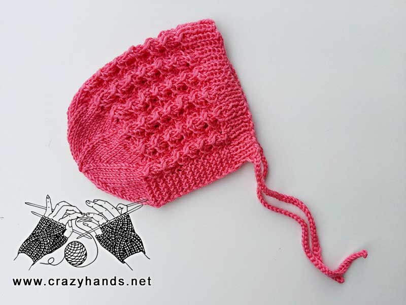 lace knit baby bonnet with ties, side view of the flat hat