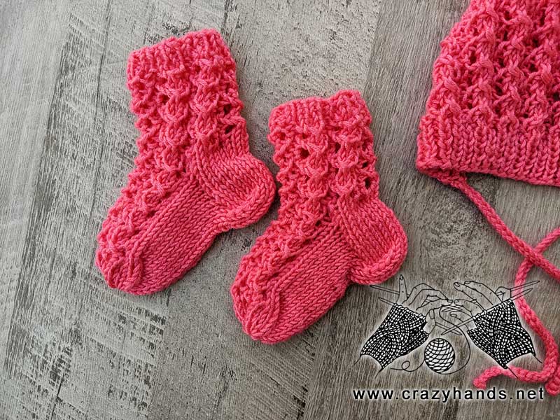 lace knit set for a newborn baby that includes a beanie and a pair of socks