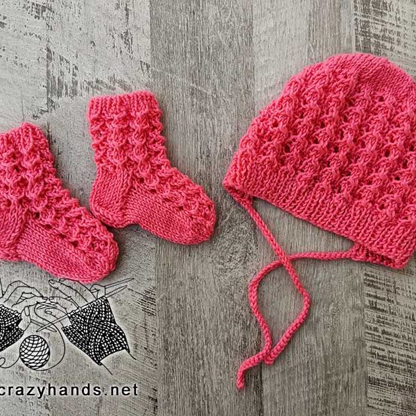 lace knit set for a newborn baby that includes a bonnet and a pair of socks