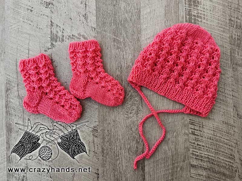lace knit set for a newborn baby that includes a bonnet and a pair of socks