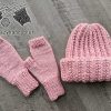 chunky knit set that includes a ribbed hat and fingerless gloves. Both items knitted with pastel pink color yarn.