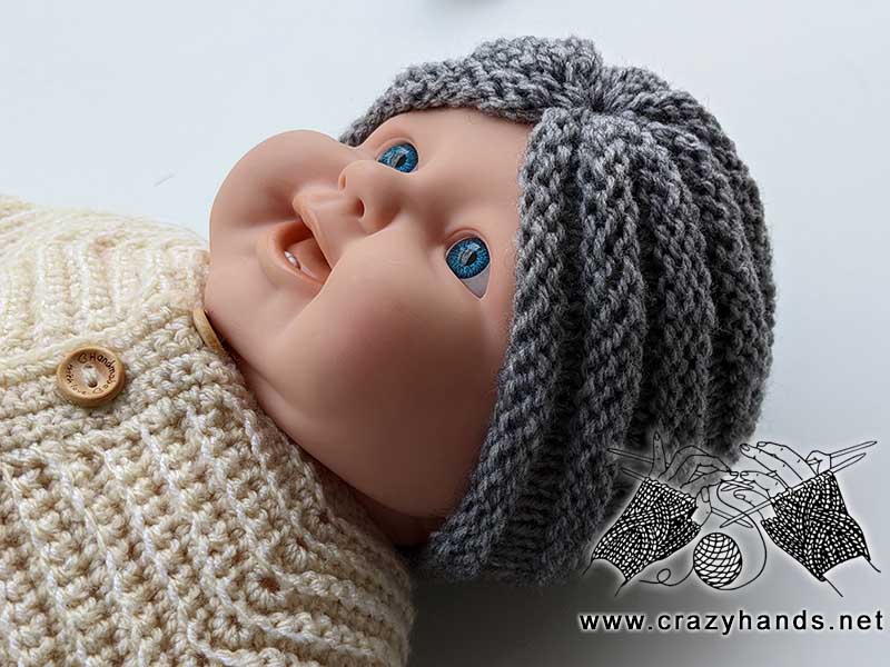 knit baby turban hat made with gray yarn on the baby mannequin - side view