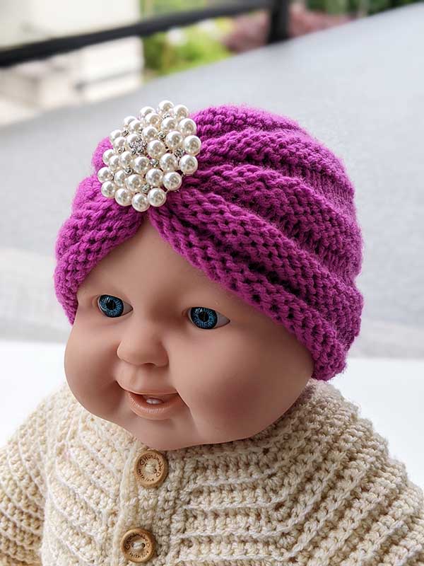 knit baby turban hat made with violet yarn on the baby mannequin - front view