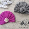 two baby knit turban hats - one decorated with a brooch and another one with a knot